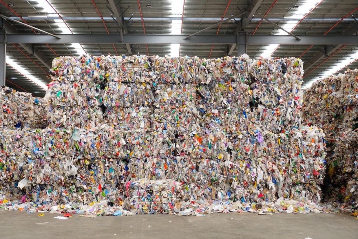 A warehouse stacked with baled plastic waste